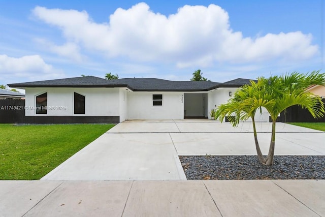 view of front of home with driveway, a front lawn, and stucco siding