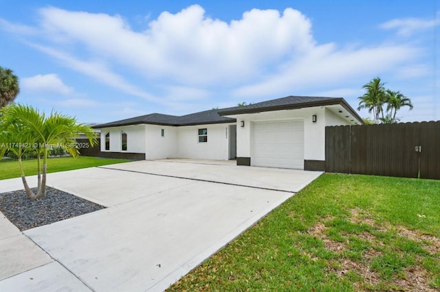 view of front of property featuring a garage, a front yard, concrete driveway, and stucco siding