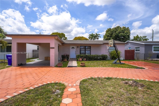 1820 N 27th Ave, Hollywood, FL 33020 - view of front facade featuring a front lawn, a carport, fence, and stucco siding