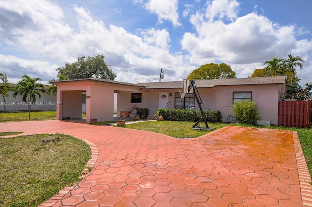 1820 N 27th Ave, Hollywood, FL 33020 - ranch-style house featuring a front yard, decorative driveway, stucco siding, and fence