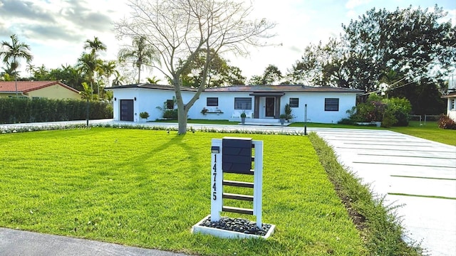 view of front of home with a front yard and stucco siding