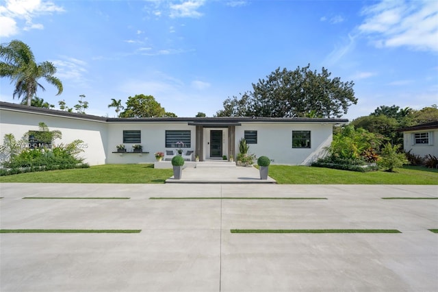 mid-century home with stucco siding and a front lawn