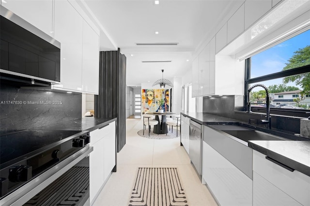 kitchen with modern cabinets, appliances with stainless steel finishes, and white cabinetry