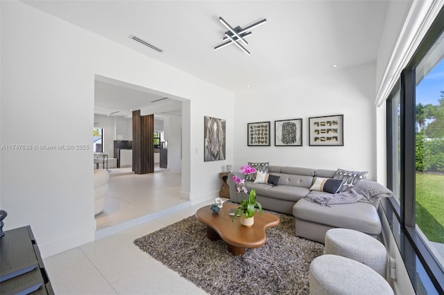 tiled living area with baseboards and visible vents
