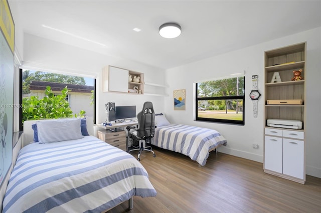 bedroom with baseboards and wood finished floors
