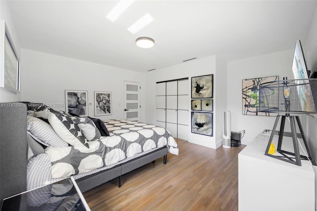 bedroom featuring visible vents and wood finished floors