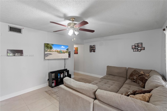 living room featuring light tile patterned floors, visible vents, ceiling fan, a textured ceiling, and baseboards