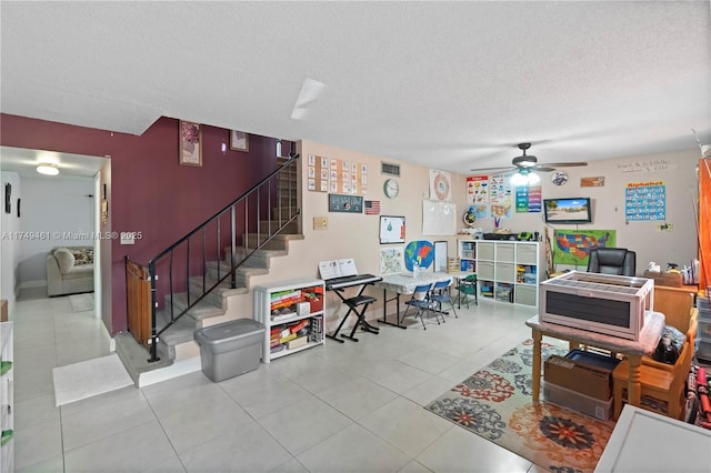 interior space with a textured ceiling, a ceiling fan, and tile patterned floors