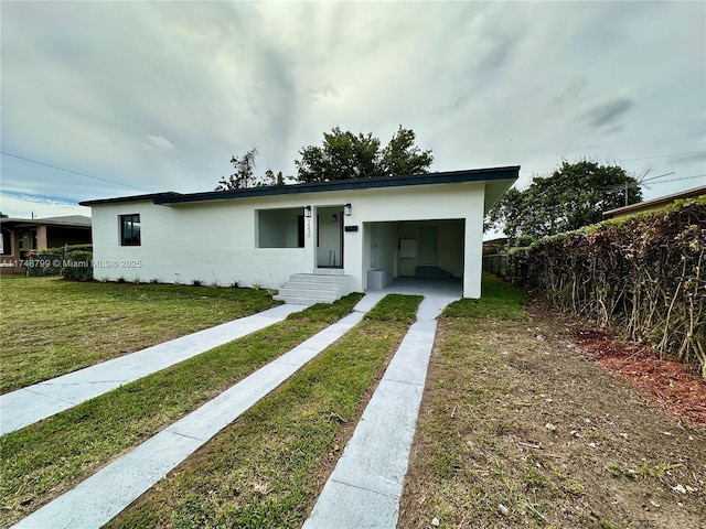 view of front facade with stucco siding and a front yard