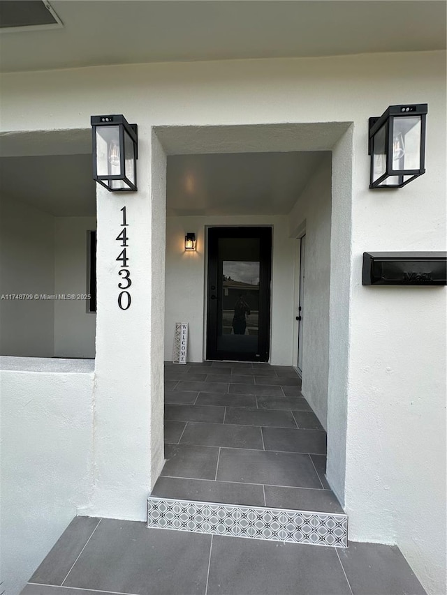 entrance to property featuring stucco siding