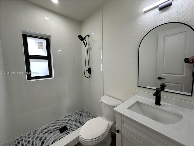 bathroom featuring toilet, a stall shower, and vanity