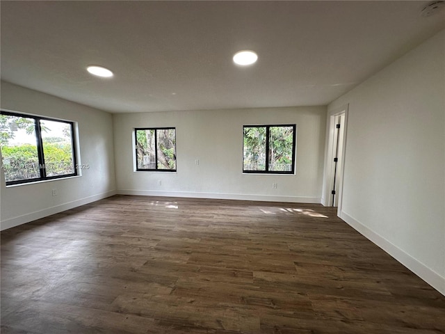 spare room with dark wood-style floors and baseboards