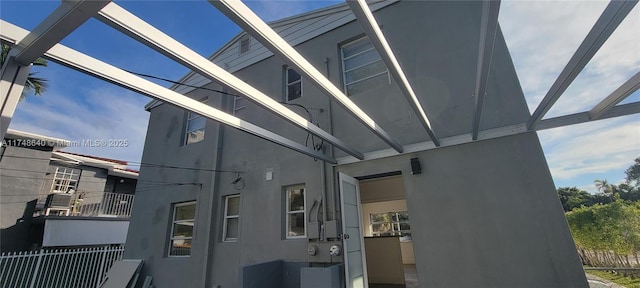 view of property exterior featuring fence and stucco siding