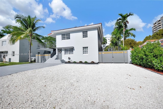 back of property with driveway, a gate, and stucco siding