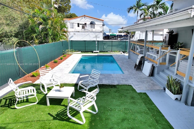 view of swimming pool with a fenced backyard, a lawn, a fenced in pool, and a patio