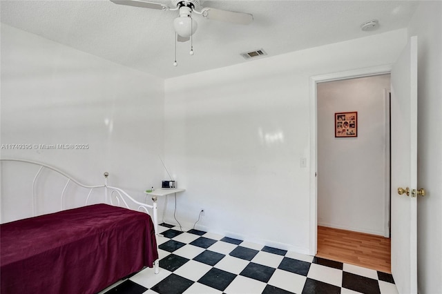 bedroom with visible vents, a textured ceiling, baseboards, and tile patterned floors