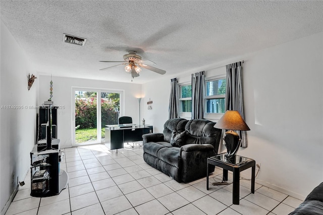 living area featuring light tile patterned floors, ceiling fan, a textured ceiling, and visible vents