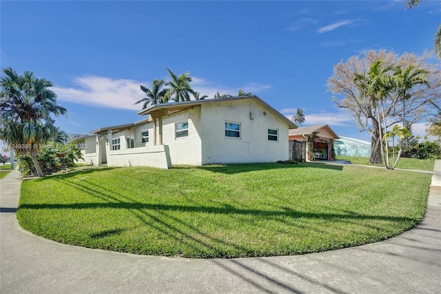 view of side of property with a yard and stucco siding