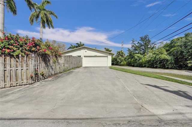 view of side of home featuring a garage and fence