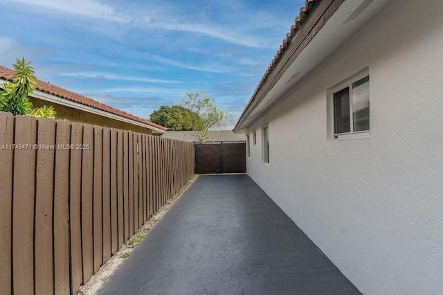 view of side of home featuring fence and stucco siding