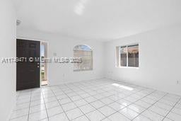 spare room with a wealth of natural light and light tile patterned floors