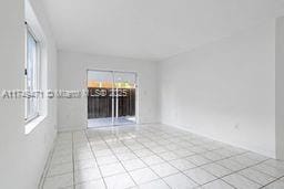 empty room with light tile patterned floors and a wealth of natural light