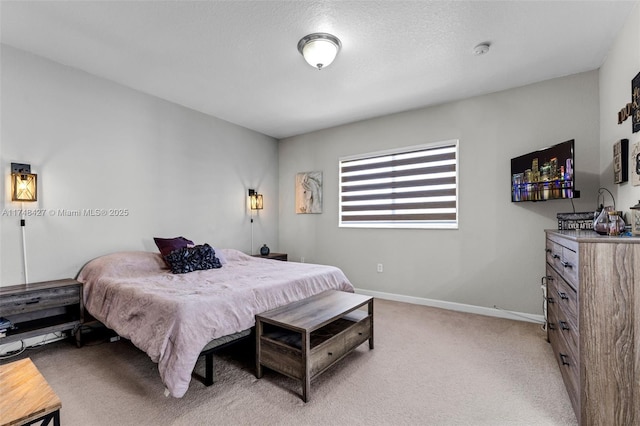 bedroom featuring baseboards, a textured ceiling, and light colored carpet