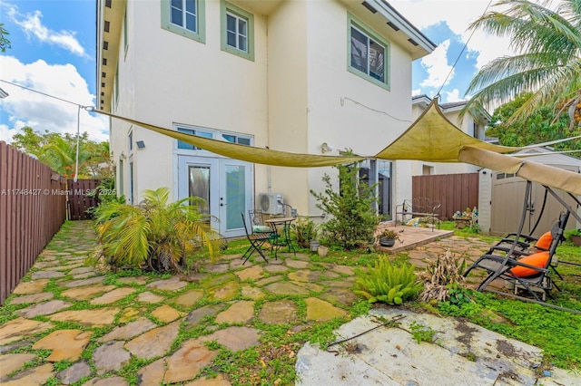 back of house with a patio area, a fenced backyard, a shed, and stucco siding