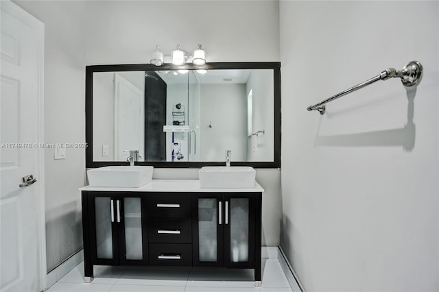 bathroom with double vanity, a sink, and tile patterned floors