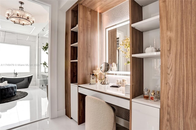 full bath with a freestanding tub, vanity, and an inviting chandelier