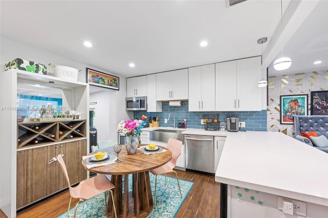 431 NE 110th Ter, Miami, FL 33161 - kitchen with stainless steel appliances, light countertops, white cabinetry, dark wood-style floors, and recessed lighting
