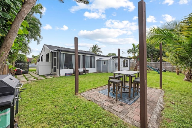 431 NE 110th Ter, Miami, FL 33161 - view of yard featuring a storage unit, a sunroom, a patio, and outdoor dining area