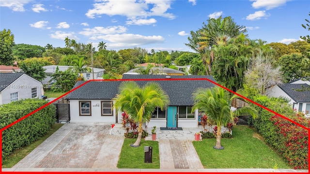 431 NE 110th Ter, Miami, FL 33161 - view of front facade featuring driveway, roof with shingles, and a front yard