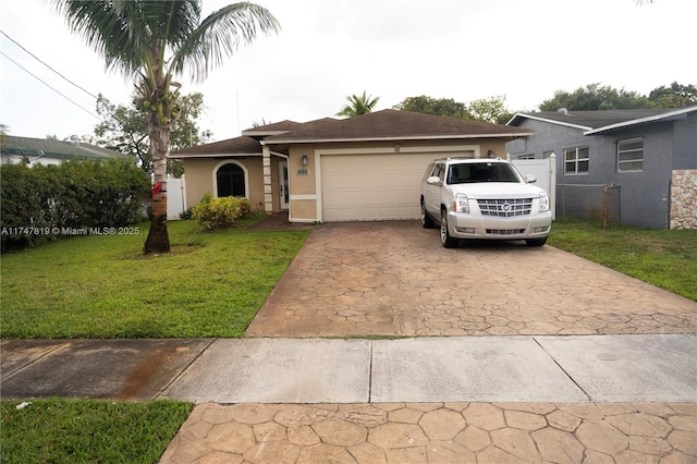 single story home with a garage, fence, concrete driveway, stucco siding, and a front yard