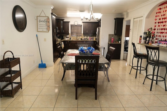 dining room featuring baseboards, crown molding, an inviting chandelier, and light tile patterned floors