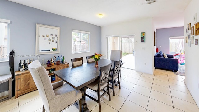 dining space featuring light tile patterned floors and visible vents