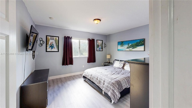 bedroom with baseboards and wood finished floors