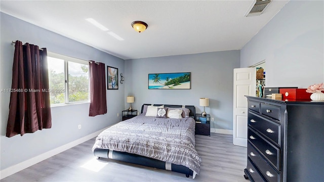bedroom featuring wood finished floors, visible vents, and baseboards