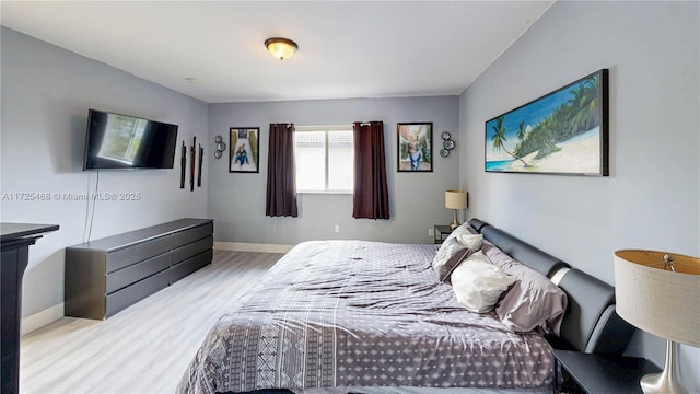 bedroom with light wood finished floors and baseboards