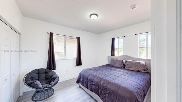 bedroom featuring light wood-style floors and baseboards