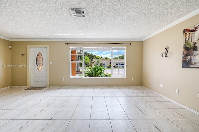 empty room featuring light tile patterned floors, visible vents, a textured ceiling, and ornamental molding