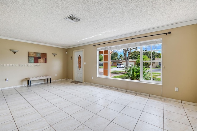 spare room with visible vents, a textured ceiling, and ornamental molding