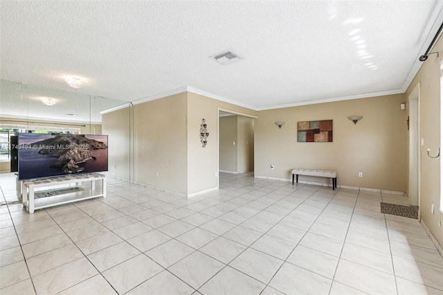 spare room featuring light tile patterned floors, visible vents, a textured ceiling, and ornamental molding