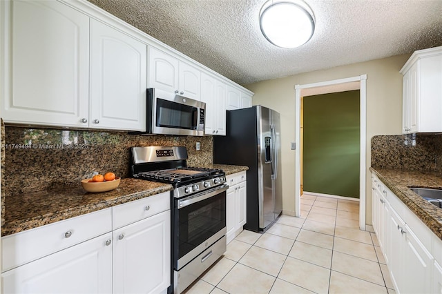 kitchen featuring stainless steel appliances, white cabinets, and light tile patterned floors