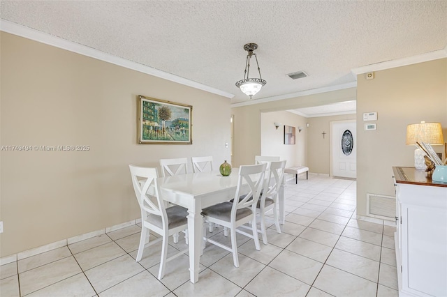 dining room featuring light tile patterned floors, ornamental molding, a textured ceiling, and visible vents