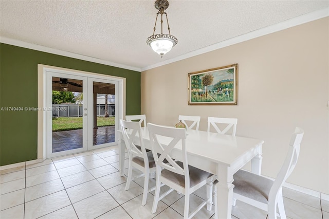 dining room with light tile patterned floors, ornamental molding, a textured ceiling, and french doors