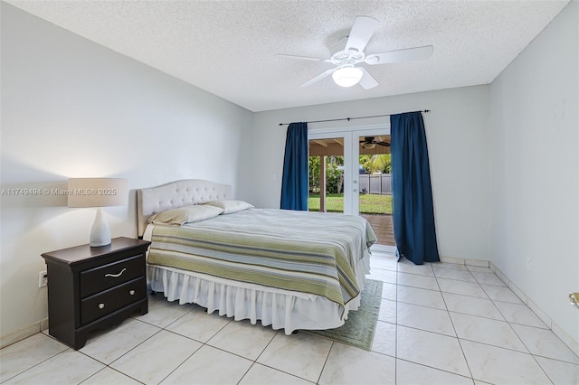 bedroom featuring access to outside, french doors, a textured ceiling, and light tile patterned floors