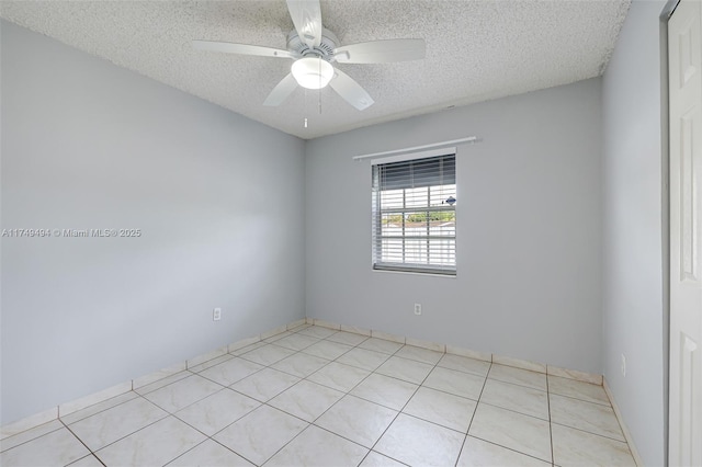 empty room with light tile patterned floors, ceiling fan, and a textured ceiling