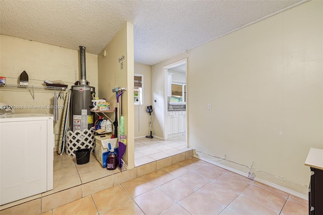 washroom featuring light tile patterned floors, a textured ceiling, gas water heater, laundry area, and washer / clothes dryer