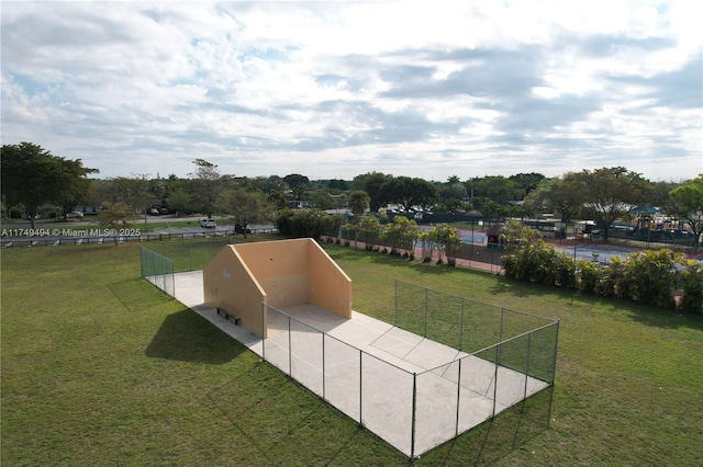 view of community featuring fence and a lawn